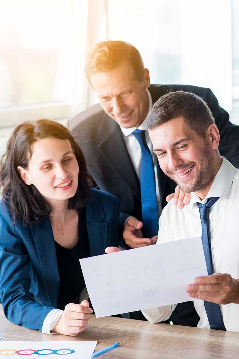 Three employees looking at a document together