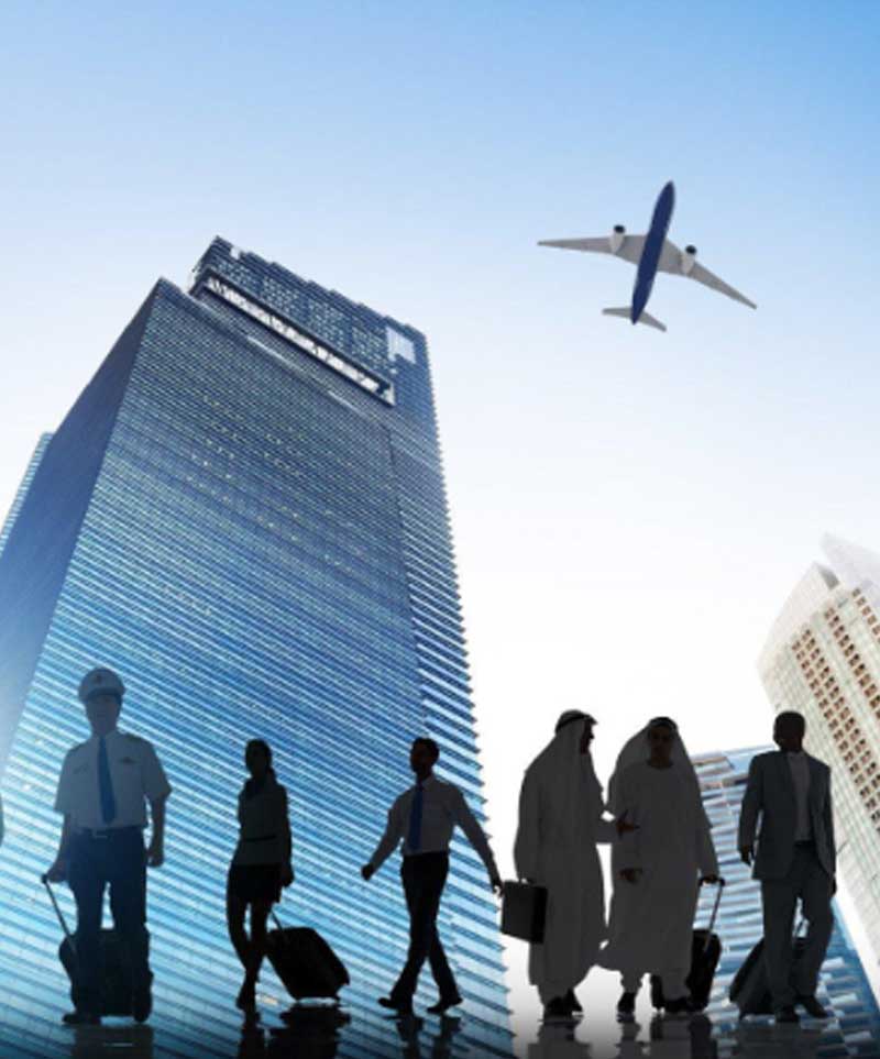 A silhouette of people walking with a building in the background and a plane flying above